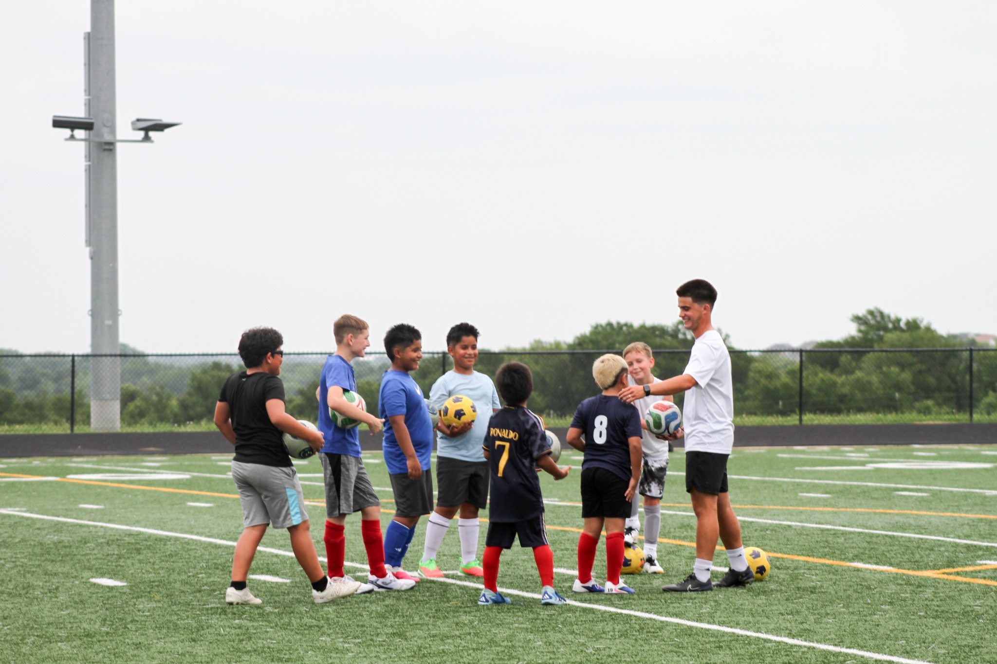 Coach Jose smiling with a group of FSA players